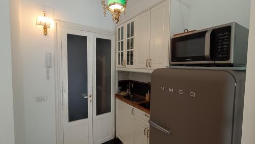 uma cozinha com um frigorífico e um micro-ondas em Elegante Monolocale - Macchi 1920 em Milão
