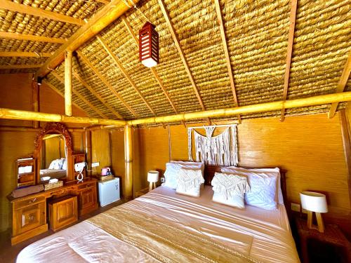 a bedroom with a bed with a wooden ceiling at Coastal Inn in Nusa Penida