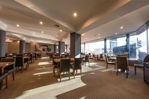 a dining room with tables and chairs and windows at Hotel Anatolia in Bursa