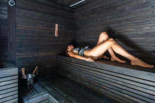 a man is laying in a sauna at Hotel Montchalet in Ortisei