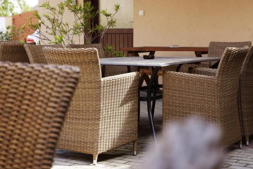 a table with wicker chairs and a table and a table and chairsktop at Pension zur Sonne in Illmitz