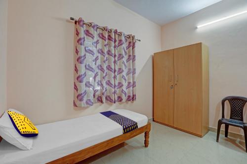 Zimmer mit einem Bett, einem Schrank und einem Vorhang in der Unterkunft SPOT ON 81069 New Mysore Stays in Mysore