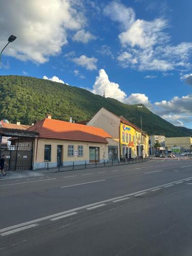 an empty street with a mountain in the background at Stay Inn Central Brasov Apartments in Braşov