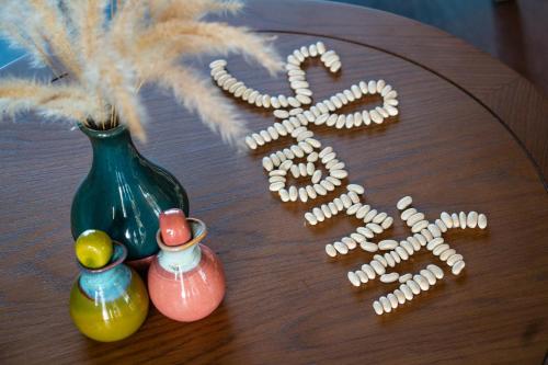 three vases sitting on a wooden table with a word at Bellerive Hoi An Resort and Spa in Hoi An