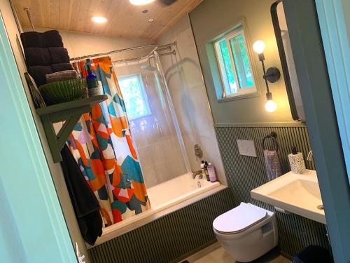 a bathroom with a shower and a toilet and a sink at Seaside House and Aloha Bungalow in Pahoa
