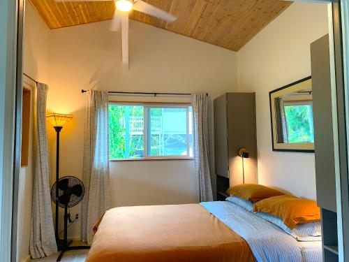 a bedroom with a bed and a window at Seaside House and Aloha Bungalow in Pahoa