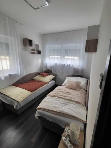 duas camas num pequeno quarto com em Flower Apartman Győr em Gyor