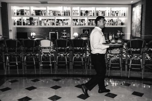 a man walking through a bar with a tray of food at Castival Hotel in Side