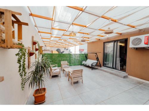 a patio with chairs and a table and a plant at Fortunella Suites in Finike