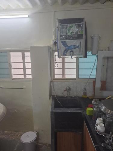 a small kitchen with a sink and a window at Private Farm Stay in Pune
