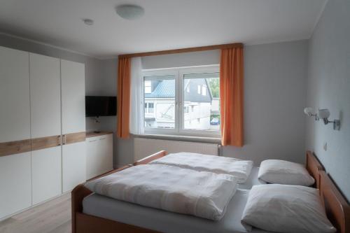 Un dormitorio con dos camas y una ventana. en Appartementhaus Christel, en Grömitz
