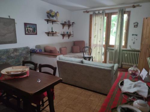 appartamento Cima في فيومالبو: غرفة معيشة مع أريكة وطاولة