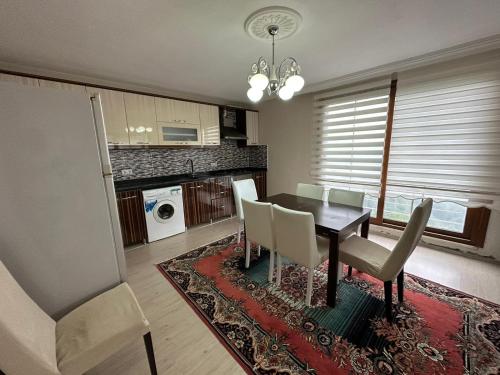 a dining room with a table and chairs and a kitchen at Doğanın içinde eşsiz manzara in Cayeli