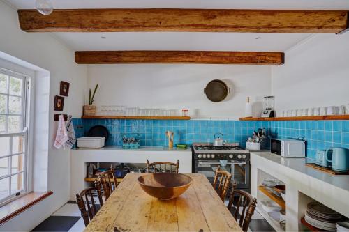 a kitchen with a wooden table and chairs at Somerset Gift Getaway Farm in Swellendam