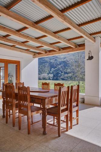 a dining room with a wooden table and chairs at Somerset Gift Getaway Farm in Swellendam