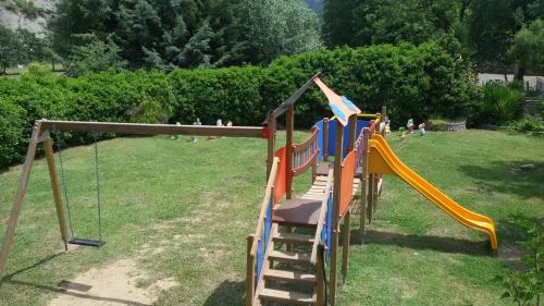 un parque infantil con un tobogán en un patio en Il Molino Della Contessa, en Castelmezzano