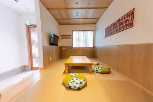 een kamer met een tafel en twee kussens op de vloer bij Irodori Hotel SAKURA in Fukuoka