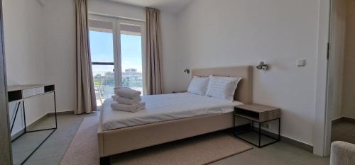 a hotel room with a bed with towels on it at iComfort Aparthotel in Timişoara