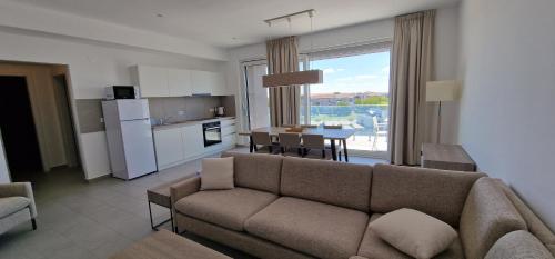 a living room with a couch and a kitchen with a table at iComfort Aparthotel in Timişoara