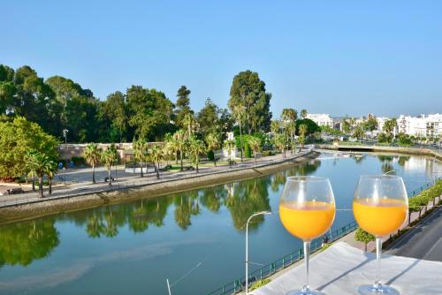 two wine glasses sitting on a ledge next to a river at Apartamento GUADIANA RÍA - Centro in Ayamonte