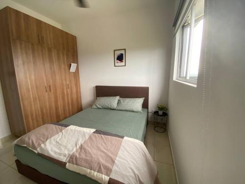 a small bedroom with a bed and a window at Alanis D'semporna Homestay in Sepang