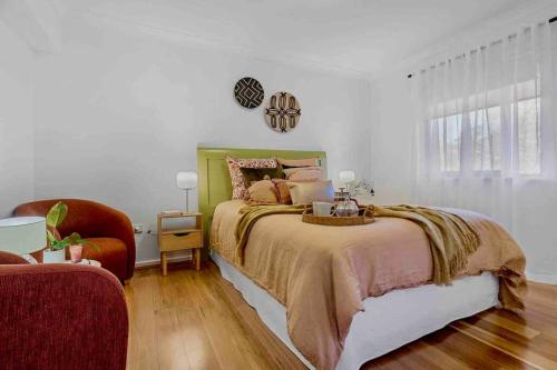 a bedroom with a bed and a chair at Stunning 2BR CBD Apartment next to King's Park in Perth