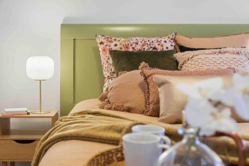 a bedroom with a bed with a green headboard and pillows at Stunning 2BR CBD Apartment next to King's Park in Perth