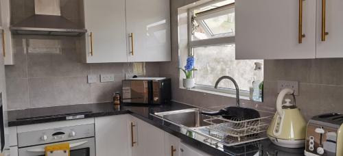 a kitchen with a sink and a microwave at Entire 2 bedroom Apt in central location, Newly Refurbished in Plymouth