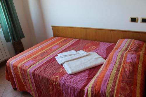 - 2 serviettes assises au-dessus d'un lit dans l'établissement Greccio Existence Oasi, à Greccio