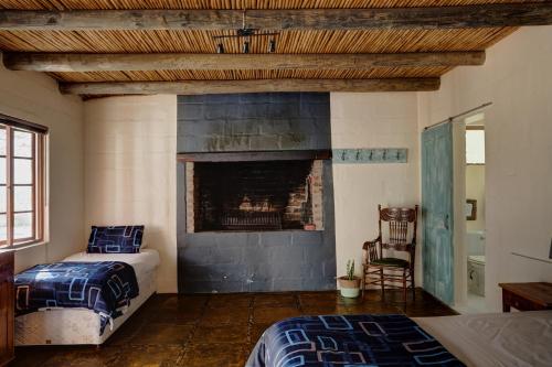 a bedroom with two beds and a fireplace at Somerset Gift Getaway Farm in Swellendam