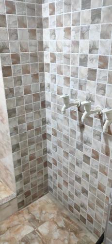 a bathroom with a tiled wall with two sinks at Dhanwantri Niwas in Varanasi