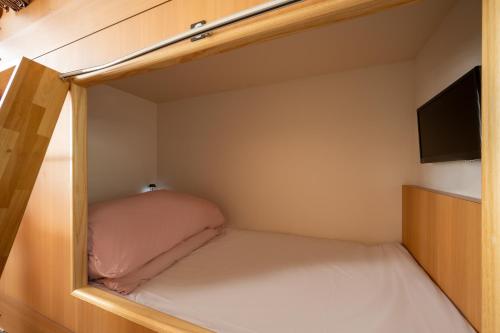 a small room with a bed and a flat screen tv at KIBOTCHA/キボッチャ in Higashimatsushima