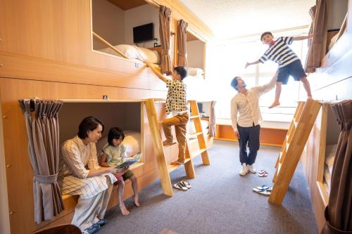 a group of people in a room with bunk beds at KIBOTCHA/キボッチャ in Higashimatsushima