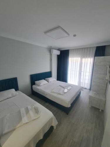 a bedroom with two beds and a window at Choras Butik Otel in Şarköy