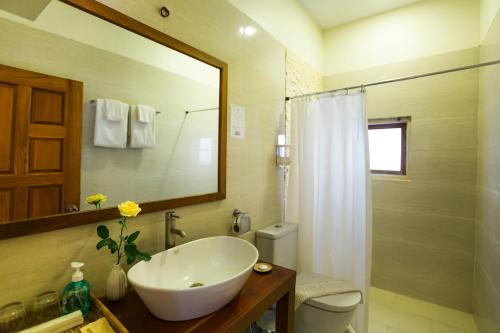 a bathroom with a sink and a toilet and a mirror at Ambassador Hill in Yangon