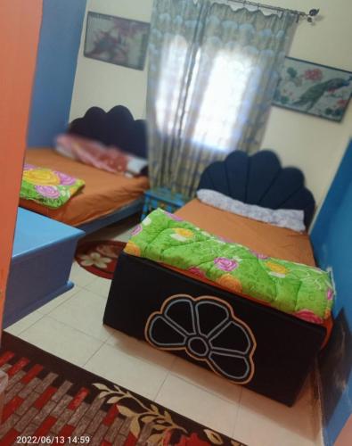 Habitación con 2 camas y caja. en استديو مكيف ب ٦٥٠ اليوم ك ٨٤ قبلي أمام زهران والزهور, en Abû Zeira