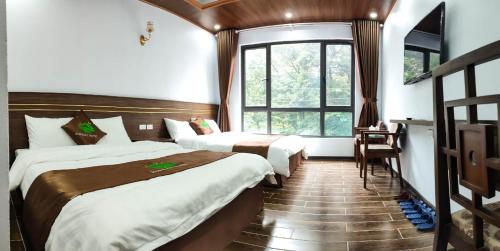 a hotel room with two beds and a window at Rosalia Tam Đảo Hotel in Tam Ðảo