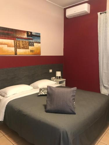 a bedroom with a bed and a red wall at Vegan Inn Airport - Adults Only in Fiumicino