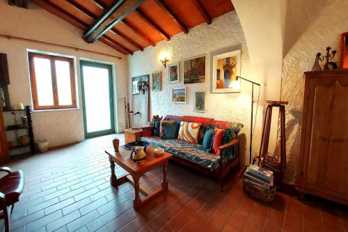 ein Wohnzimmer mit einem Sofa und einem Tisch in der Unterkunft Family Friendly Rosa House Amazing View - Happy Rentals in Barga