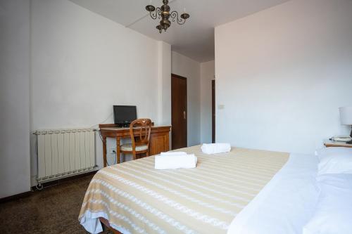 a bedroom with a bed and a desk with a computer at Hotel Napoleon in Pontremoli