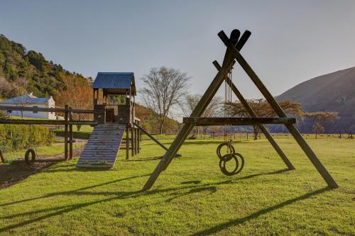 a playground with a slide and a swing at Somerset Gift Getaway Farm in Swellendam