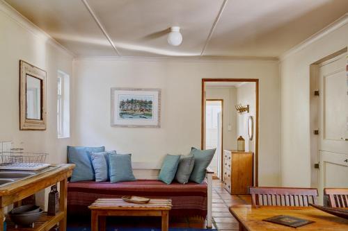 a living room with a red couch with blue pillows at Somerset Gift Getaway Farm in Swellendam