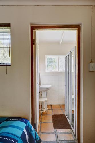 a room with a bathroom with a sink and a mirror at Somerset Gift Getaway Farm in Swellendam
