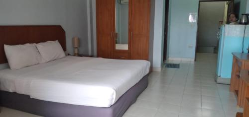 a bedroom with a white bed and a bathroom at Kingfisher House and Bar in Pattaya South