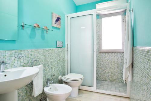 a blue bathroom with a toilet and a sink at siciliacasevancaze - Villa Torre in Punta Secca