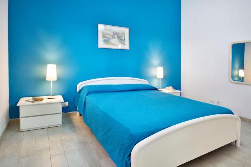 a blue bedroom with a bed and two night stands at siciliacasevancaze - Villa Torre in Punta Secca