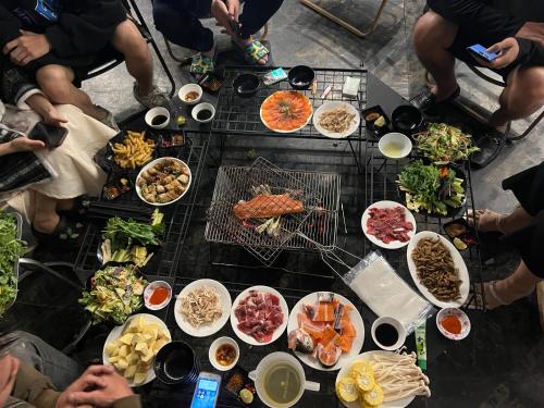 un grupo de personas sentadas alrededor de una mesa con comida en Anh Séo Homestay, en Sa Pa