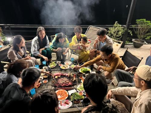 a group of people sitting around a table eating food at Anh Séo Homestay in Sa Pa