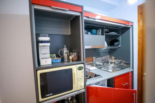 a small kitchen with a microwave and a sink at Adriana's downtown studio-parking lot included in Patra