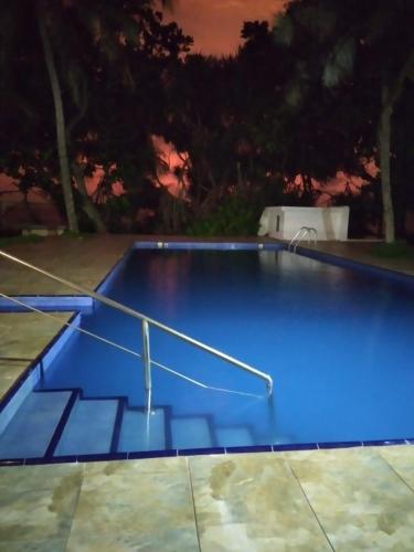 a large blue swimming pool at night at Olivia Bungalow in Wattala